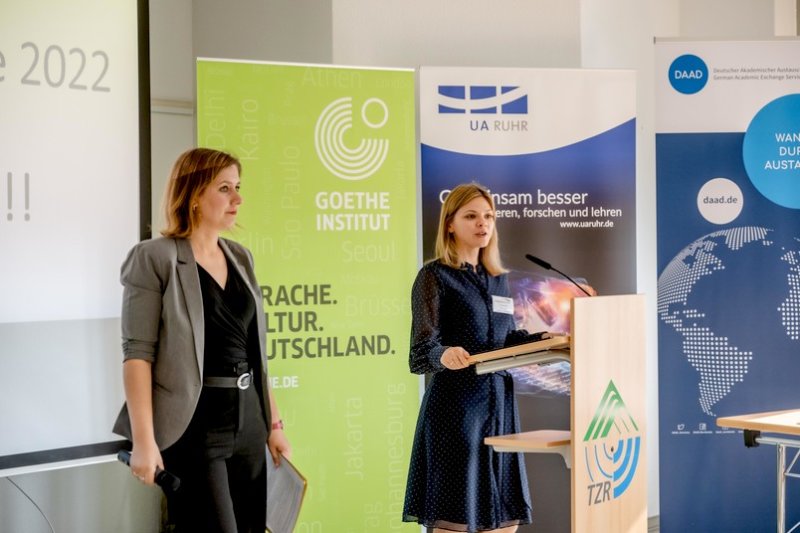 Elena Resch (links), Koordinatorin des Programms in der Universitätsallianz Ruhr, und Vita Tymchenko, Projektleiterin Studienbrücke beim Goethe-Institut, begrüßen die Teilnehmerinnen und Teilnehmer des ersten Alumni-Treffens an der RUB.