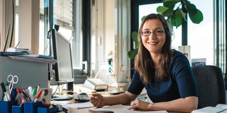 Julia Tjus sitzt am Schreibtisch.