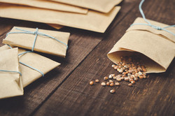 A few seeds fall out of a paper bag onto a wooden table