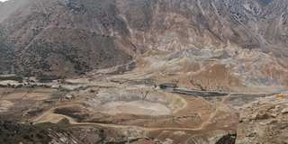 Eine bergige Landschaft und ein Tal. In dem Tal befindet sich ein großer Krater.