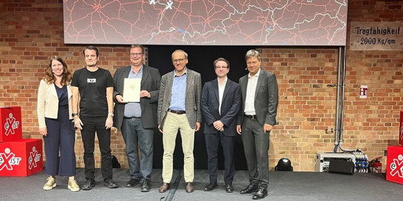 Gruppenfoto mit UA Ruhr-Vertretern auf einer Bühne, rechts Bundeswirtschaftsminister Robert Habeck