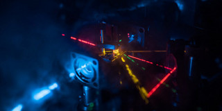 Nahaufnahme eines spektroskopischen Geräts. Zu sehen sind verschiedene Laserstrahlen.
