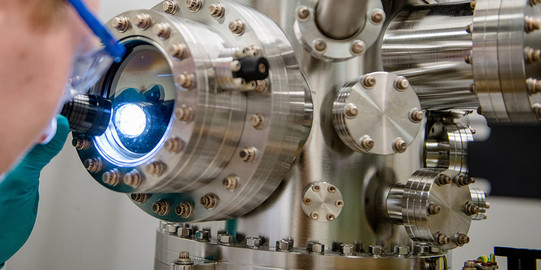 Cutaway of a person shining a flashlight into the opening of a laboratory apparatus