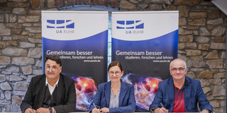 Drei Rektoren unterschreiben einen Vertrag.