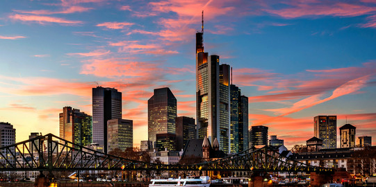 Skyline of Frankfurt am Main, in the foreground the Main river with a bridge, dusk