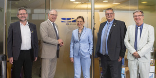 Five people in front of an office door