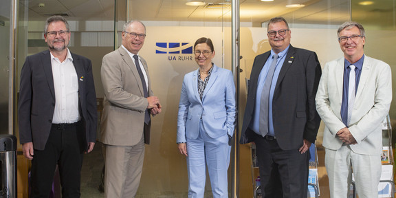Five people in front of an office door
