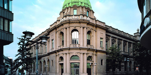 Äußere Ansicht eines Gebäudes in Essen. Das Gebäude hat eine große, grüne Kuppel und trägt den Schriftzug "Deutsche Bank"