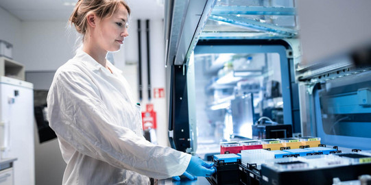 Eine Wissenschaftlerin bearbeitet Proben mit einem Sampling-Roboter