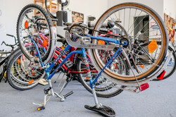 An upturned bicycle being repaired. More bikes can be seen in the background.