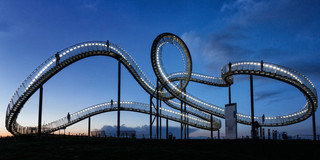 Foto: Die Skulptur "Tiger and Turtle – Magic Mountain" bei Nacht.
