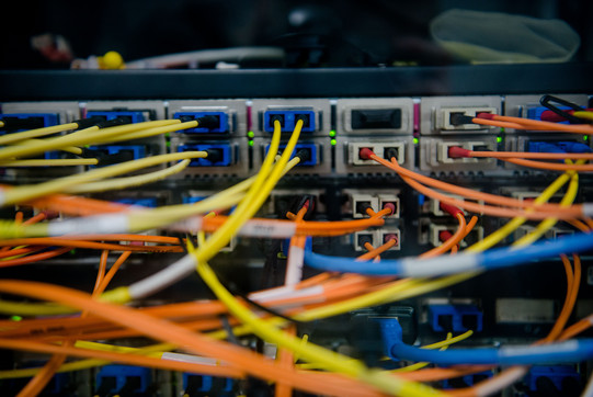 Back of a server with a colorful tangle of cables coming out of it