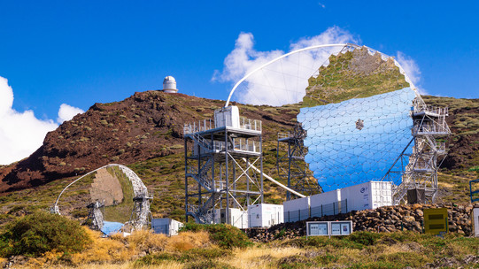 MAGIC-Teleskope auf La Palma, ein kleines und großes, futuristisch wirkendes, verspiegeltes Teleskop
